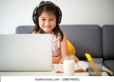 Asian girl using Laptop computer for online study homeschooling during home quarantine. homeschooling, online study, home quarantine, online learning, corona virus or education technology concept