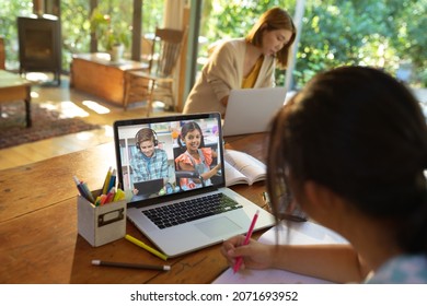 Asiatisches Mädchen, das einen Laptop für Videoanrufe nutzt, mit Lächeln verschiedener Schüler an der Grundschule auf dem Bildschirm. Kommunikationstechnologie und Online-Bildung, digitales Verbundbild.