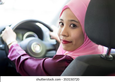 Asian Girl wearing hijab  Driving Happy smiling in a car
