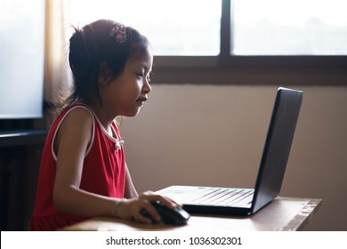 The asian girl works on a computer,at home. - Shutterstock ID 1036302301