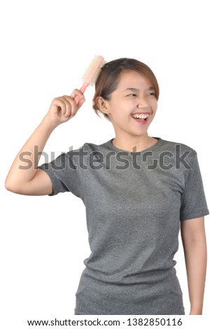 Asian girls in casual shirts combing their hair on white background
