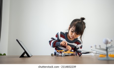 Asian girls enjoy making and fixing electrical robot car and learning online tutor training course - Shutterstock ID 2114832239