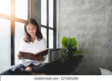 Asian Girls Are Sitting Reading Books Happily.