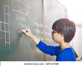 Asian Grade School Student Solving A Geometry Problem On Chalkboard In Math Class.