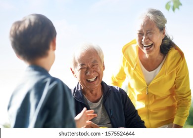 Asian Grandfather Grandmother And Grandson Having Fun Outdoors In Park