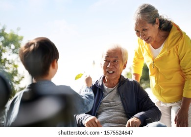 Asian Grandfather Grandmother And Grandson Having Fun Outdoors In Park