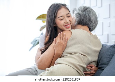 Asian Grandma And Granddaughter Hugged With Happy Mood On The Sofa In Home.