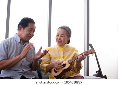 Asian Grandma Grandpa Playing Ukulele With Smile In Living Room