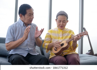 Asian Grandma Grandpa Playing Ukulele With Smile In Living Room