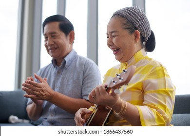 Asian Grandma Grandpa Playing Ukulele With Smile In Living Room