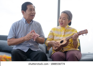 Asian Grandma Grandpa Playing Ukulele With Smile In Living Room