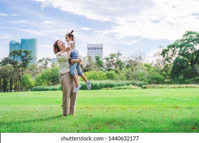 Asian grandmother and grandchildren having happy time together in park, family enjoy playing at green grass field outdoor in summer time vacation holiday concept background