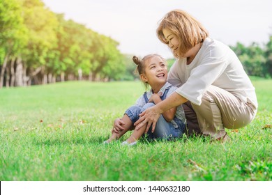 Asian grandmother and grandchildren having happy time together in park, family enjoy playing at green grass field outdoor in summer time vacation holiday concept background