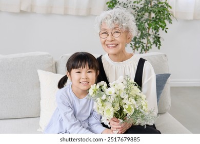 Asian grandmother and her grandchild  having the bouquet in the living room - Powered by Shutterstock