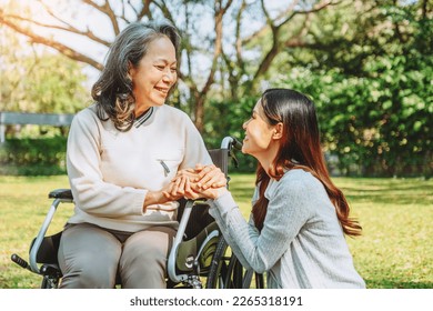 Asian grandmother in wheelchair with daughter is enjoying at the park in the morning - Shutterstock ID 2265318191