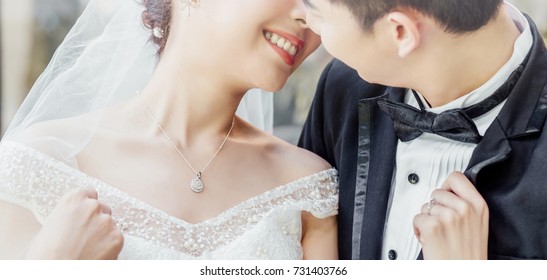 Asian groom and Asian bride are close together and are about to kiss each other with a smiling and happy face.