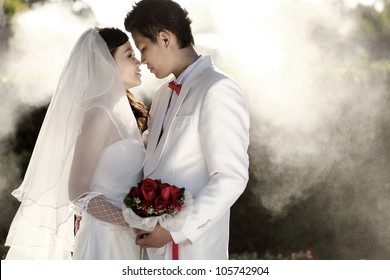 Asian groom and bride embrace