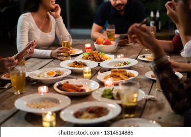 Asian Group Eating And Drinking Cold Beer Outside The House At Night, Having Fun Talking