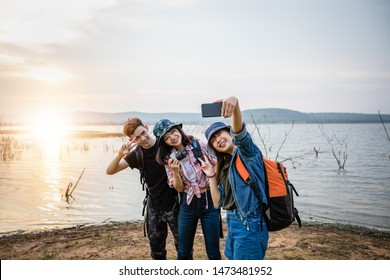 Asian Group Of Young People With Friends And Backpacks Walking Together And Happy Friends Are Taking Photo And Selfie ,Relax Time On Holiday Concept Travel