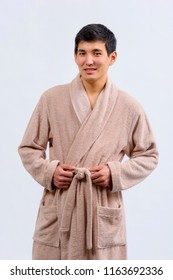 Asian Guy In A Bathrobe. A Kazakh Man In A Dressing Gown On A Light Background.