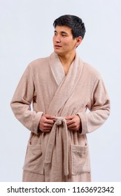 Asian Guy In A Bathrobe. A Kazakh Man In A Dressing Gown On A Light Background.