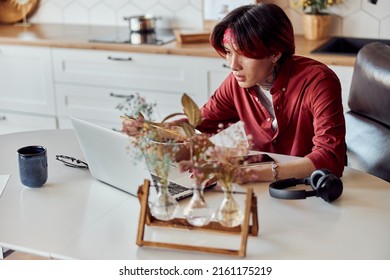 Asian Guy Eating Noodles And Working Online At Home