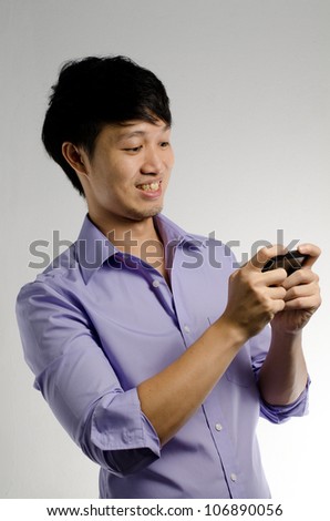 Asian guy play game or texting on his smart phone