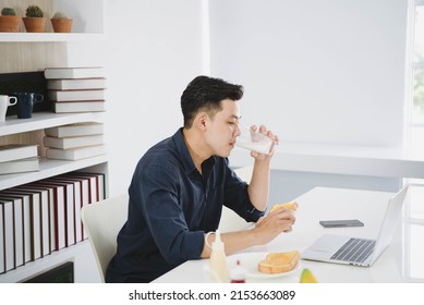 Asian Handsom Business Man Working In White Moden Office While Having Breakfast