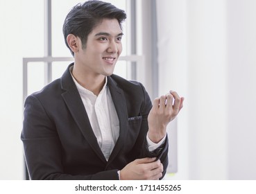 An Asian Handsome Business Man Is Dressing Up And Fixing Cufflink