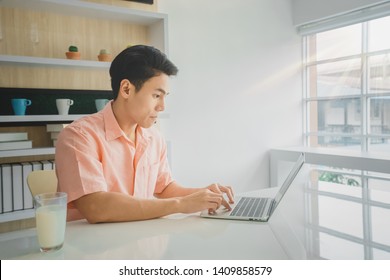 A Asian Handsome Businessman 24s Working With Laptop On Desk In Workplace., A Handsome 24 Year Old Asian Male Student Is Learning Use A Laptop On The Table In The House.back To School. Work Form Home