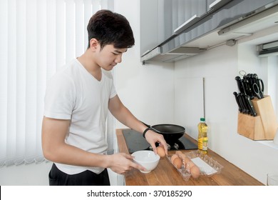 Asian Handsome Man Cooking In The Kitchen At Home