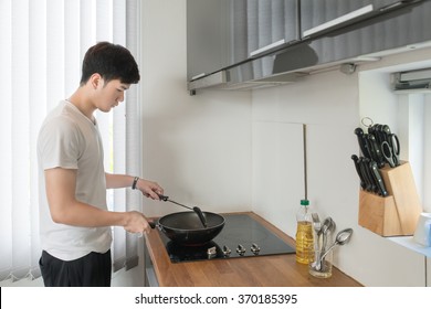 Asian Handsome man cooking in the kitchen at home