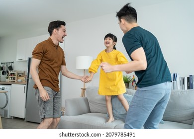 Asian Handsome Man Gay Family Dance Together With Young Kid Daughter. Attractive Romantic Male Lgbt Couple Spend Time And Enjoy Listen To Music, Have Fun With Little Girl Child In Living Room At Home.