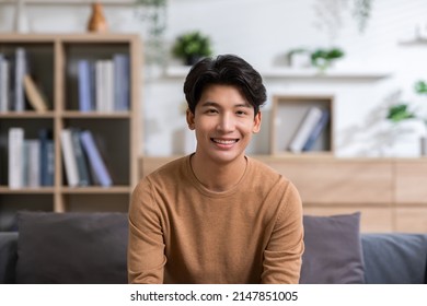 Asian Handsome Man Looking At Camera Smile At Home.Happy Young Smart Businessman Smile And Confidence.Positive And Good Moment Of Asian Male Worker Smile  With Wellness Life