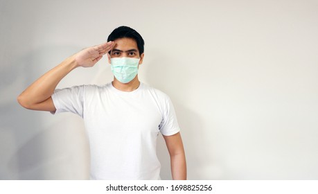 Asian handsome man wearing a medical protective mask act saluting gesture. Concept of showing strong pride protection against pm2.5 and coronavirus covid-19. Isolated on white with copy space - Shutterstock ID 1698825256
