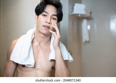 Asian Handsome Young Man Applying Cream For Skin Care On Face