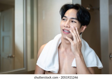 Asian Handsome Young Man Applying Cream For Skin Care On Face