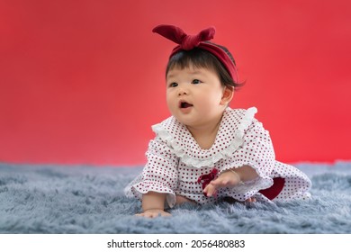 Asian Happy Baby Crawling On Red Color Background. Cute 6 Months Baby With Copy Space Use As Concept Of Bedroom, Drypers, Development, Baby Or Kid Department In Hospital.