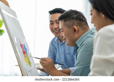 Asian Happy Family Draw Picture With Young Son In Living Room At Home. Beautiful Loving Mother And Father Take Care And Teach Young Man Patient To Painting Artwork Indoors At House. Lifestyle Activity