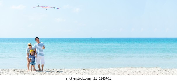 Asian happy family have fun and play kite on the beach.  Family people tourism travel in summer and holiday  for leisure and destination. Travel and Family Concept, copy space for banner