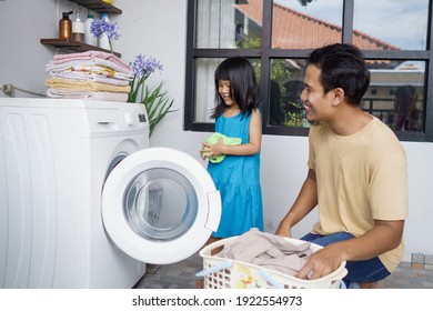 Asian Happy Family Man Father Householder And Child Daughter In Laundry With Washing Machine Together