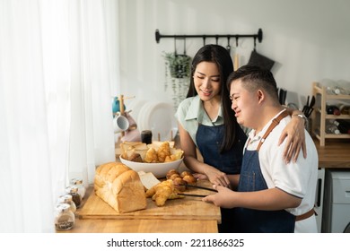 Asian Happy Family, Mature Mother Baking Bakery With Son In Kitchen. Attractive Beautiful Loving Parent, Mom Take Care And Teaching Young Man Cooking Food Breakfast Indoors At Home. Lifestyle Activity