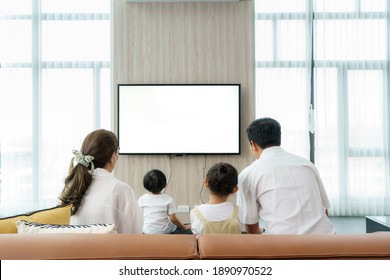 Asian happy family sitting and watching television in living room at home and spent quality time together for activity in vacation day, holiday, happiness or lifestyle concept.