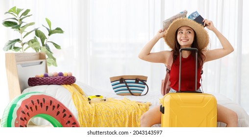 Asian Happy Female Traveler Imagines For Happiness Holiday With Happy Face, Holding Passport, Airplane Travel Flight Tickets And Paper Map Overhead With Yellow Trolley Luggage Ready For Vacation Trip.