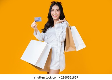 Asian Happy Female Woman Girl Holds Colourful Shopping Packages   And Cashless Credit Card Payment Studio Shot, Close Up Portrait Young Beautiful Attractive Girl Smiling Looking At Camera With Bags