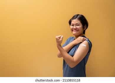 Asian Happy Girl Show Confidence And Showing Her Arm With Bandage After Got Vaccinated, Teenager Immunization, Covid Preventive Vaccine.