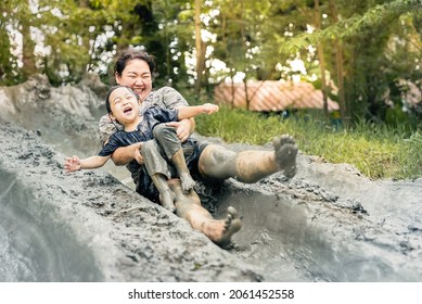 Asian happy mother and child have activities together on holidays. Mom and her son playing slider that made from mud. Happy harmonious family outdoors and learning concept. - Powered by Shutterstock