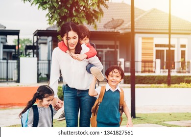 Asian Happy Mother Mom Or Parent Walking Out From Home Holding Hands Her Group Pupil Kids Kindergarten With School Bag Going To School, Back To School Concept