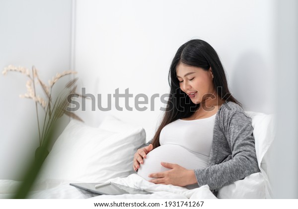 Стоковая фотография 1931741267 Asian Happy Pregnant Woman Sitting