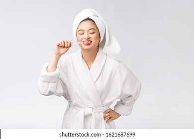 Asian happy woman with toothbrush in bathrobe morning mood - Powered by Shutterstock